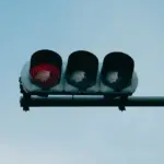 Світлофор із червоним сигналом для автомобілів, пішоходів і велосипедистів у центрі Києва під час хвилини мовчання о 09:00